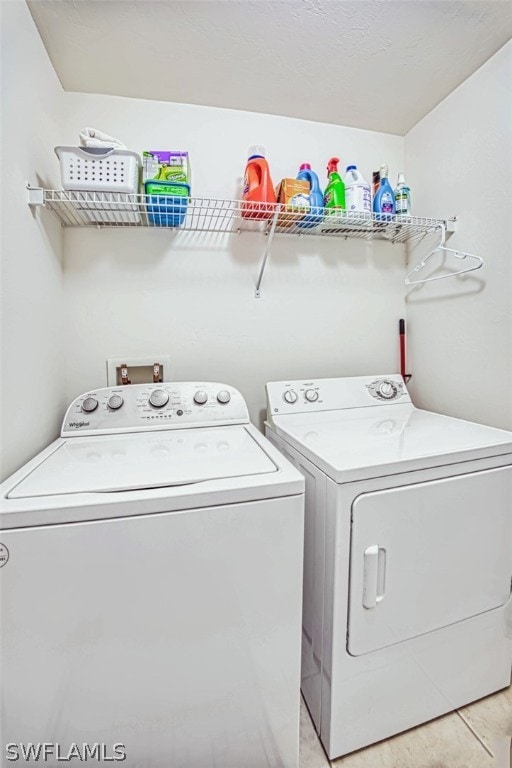 washroom featuring washer and clothes dryer, light tile flooring, and hookup for a washing machine