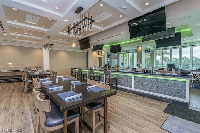 dining space featuring beam ceiling, light hardwood / wood-style floors, coffered ceiling, and plenty of natural light