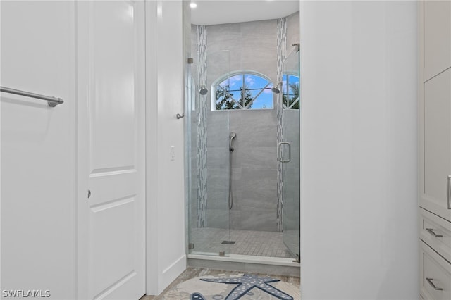 bathroom with a shower with door