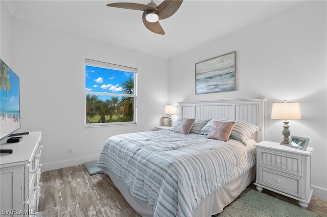 bedroom with ceiling fan, crown molding, and hardwood / wood-style flooring