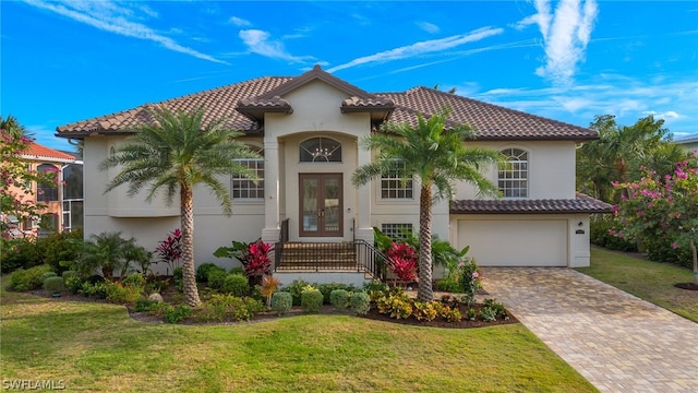 mediterranean / spanish home with a garage and a front yard