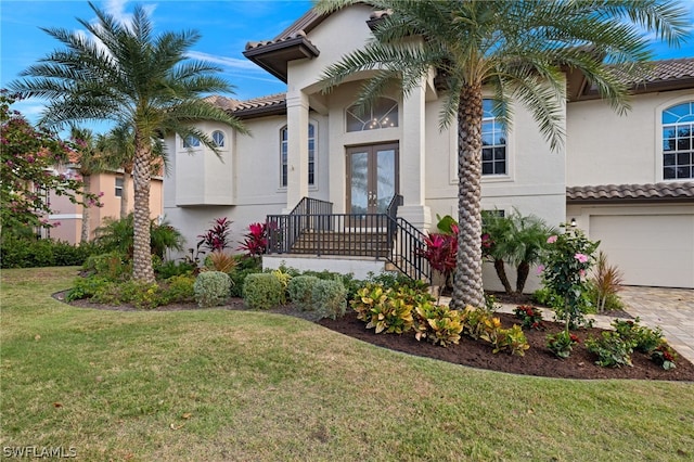 mediterranean / spanish-style house featuring a garage and a front yard