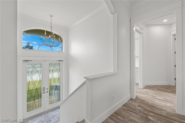 entryway featuring hardwood / wood-style floors, an inviting chandelier, and french doors