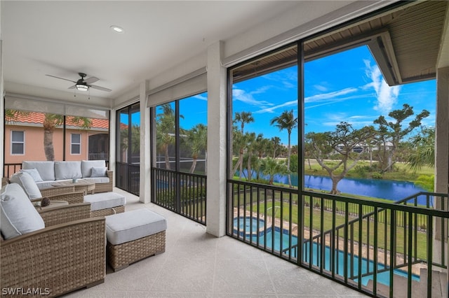 sunroom / solarium featuring ceiling fan and a water view