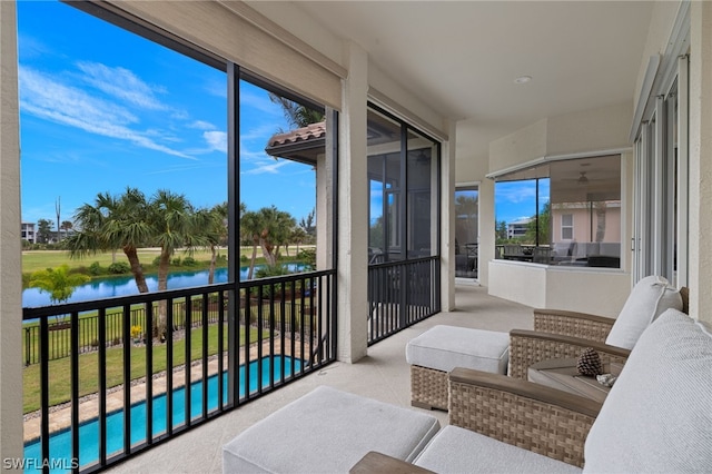 sunroom featuring a water view