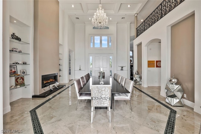 tiled dining area featuring beamed ceiling, a chandelier, built in shelves, a towering ceiling, and coffered ceiling