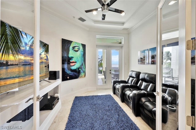 living room featuring french doors, ornamental molding, ceiling fan, and a tray ceiling