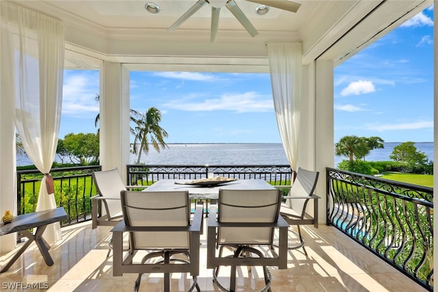 balcony with a water view and ceiling fan