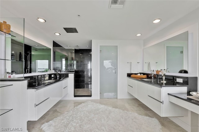 bathroom featuring vanity with extensive cabinet space, double sink, and tile floors