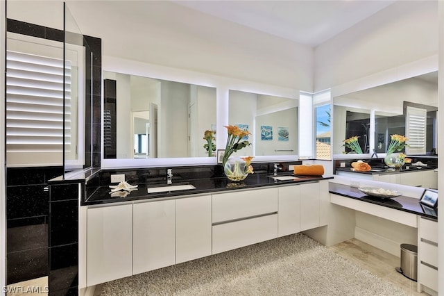 bathroom with a healthy amount of sunlight and double sink vanity