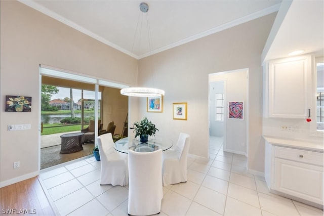 dining space featuring light tile patterned floors and ornamental molding