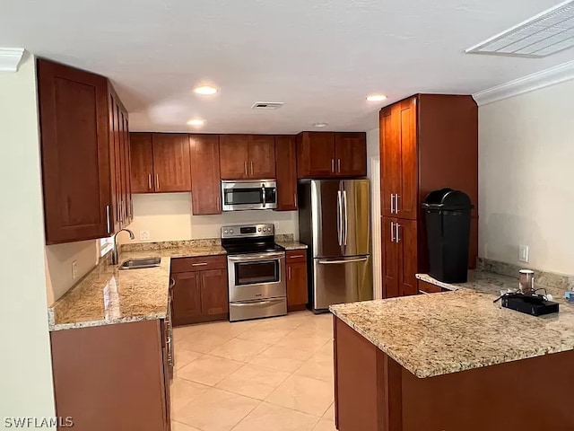 kitchen with light stone countertops, stainless steel appliances, kitchen peninsula, sink, and light tile floors