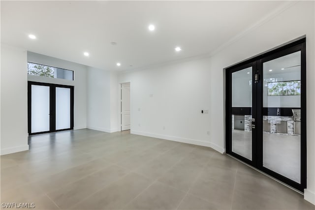 spare room with french doors, plenty of natural light, tile floors, and crown molding