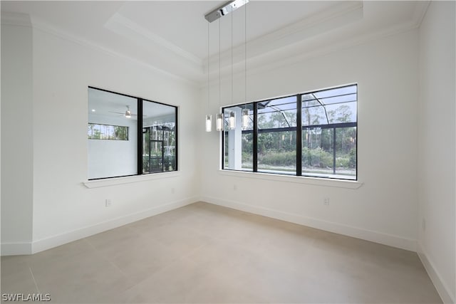 tiled empty room with ornamental molding, ceiling fan, and a raised ceiling