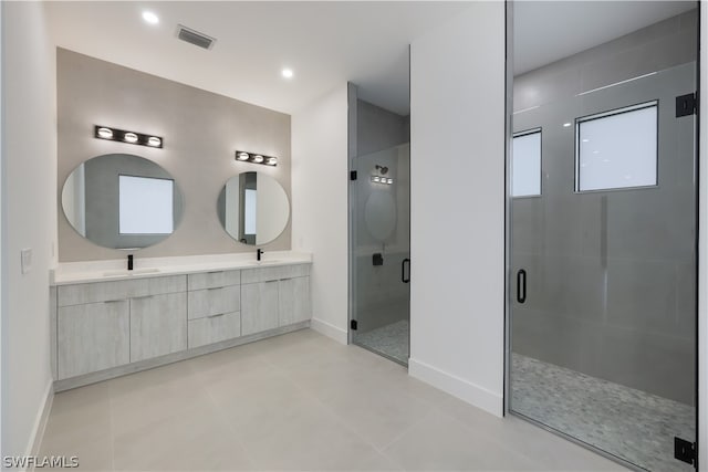 bathroom with tile flooring, dual vanity, and a shower with shower door