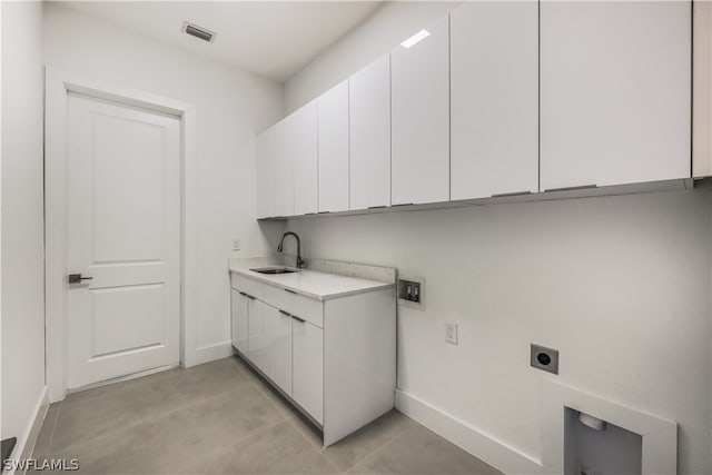 clothes washing area featuring cabinets, sink, hookup for an electric dryer, and light tile floors