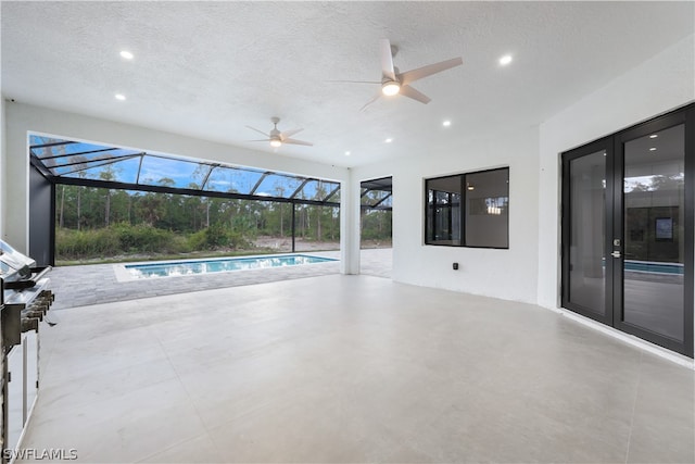 unfurnished living room featuring a textured ceiling, ceiling fan, and tile flooring