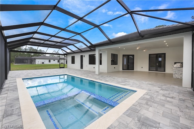 view of pool featuring a patio area, ceiling fan, an in ground hot tub, and glass enclosure