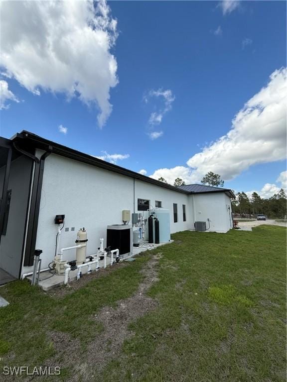 rear view of house with a yard and cooling unit