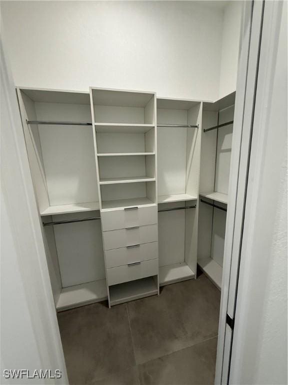 walk in closet featuring dark tile patterned floors