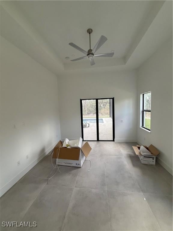 empty room featuring ceiling fan and a tray ceiling