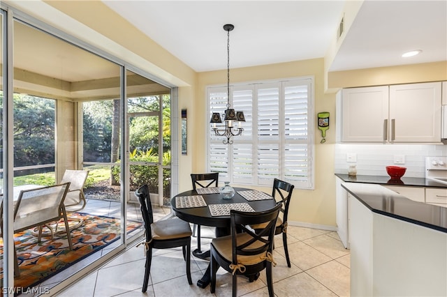 tiled dining area featuring an inviting chandelier