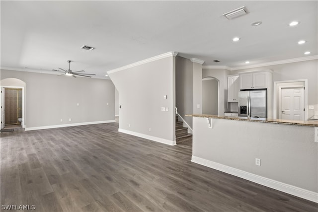 unfurnished living room featuring ceiling fan, dark hardwood / wood-style flooring, and ornamental molding