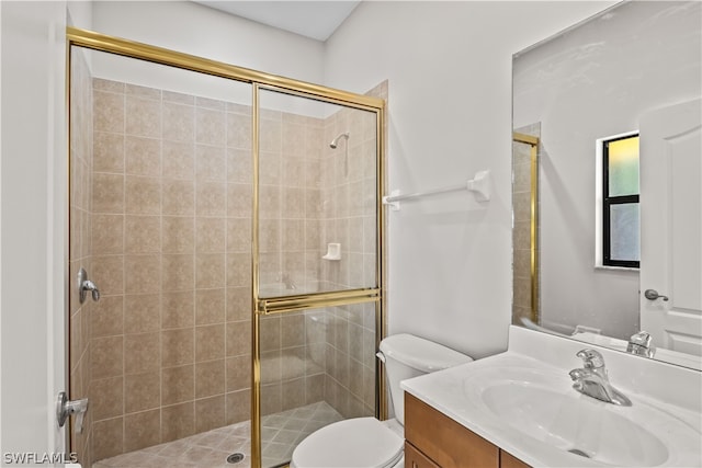 bathroom with vanity with extensive cabinet space, an enclosed shower, and toilet