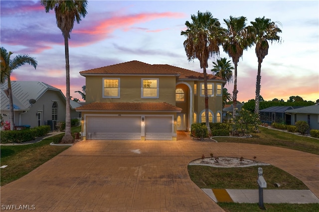 mediterranean / spanish-style house with central AC and a garage