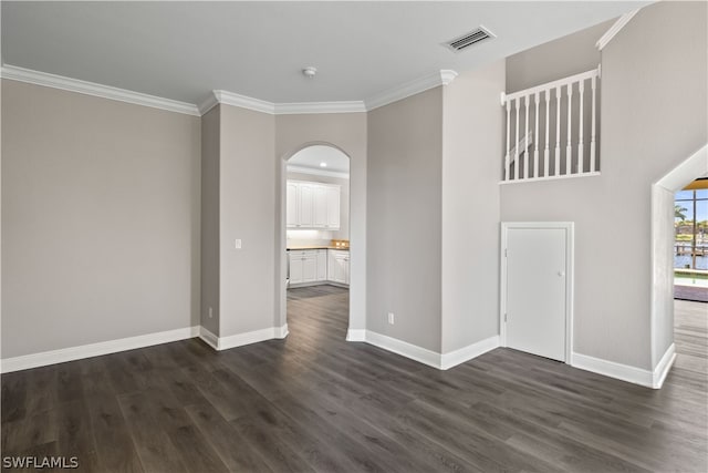 unfurnished living room with crown molding and dark wood-type flooring