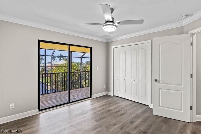 unfurnished bedroom featuring ceiling fan, crown molding, access to exterior, wood-type flooring, and a closet