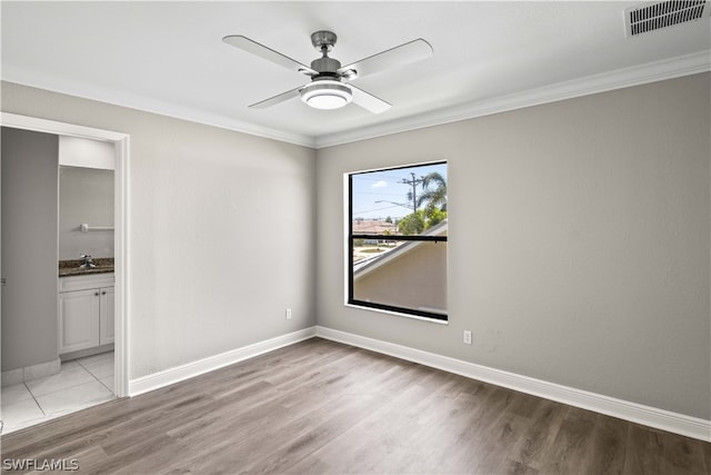 empty room featuring light hardwood / wood-style flooring, ceiling fan, and crown molding