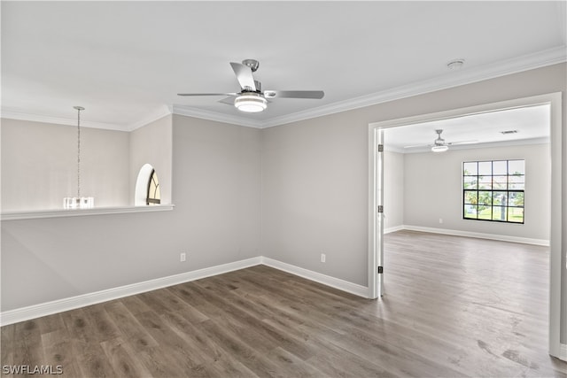 unfurnished room featuring dark hardwood / wood-style flooring, ceiling fan with notable chandelier, and crown molding