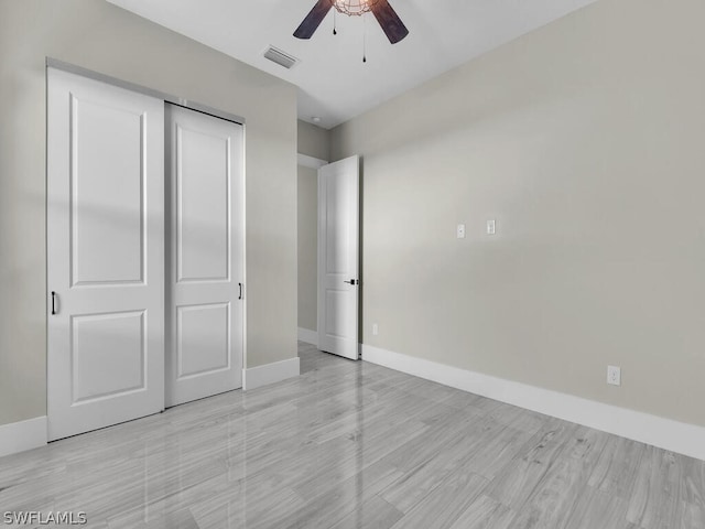 unfurnished bedroom with light wood-type flooring, a closet, and ceiling fan