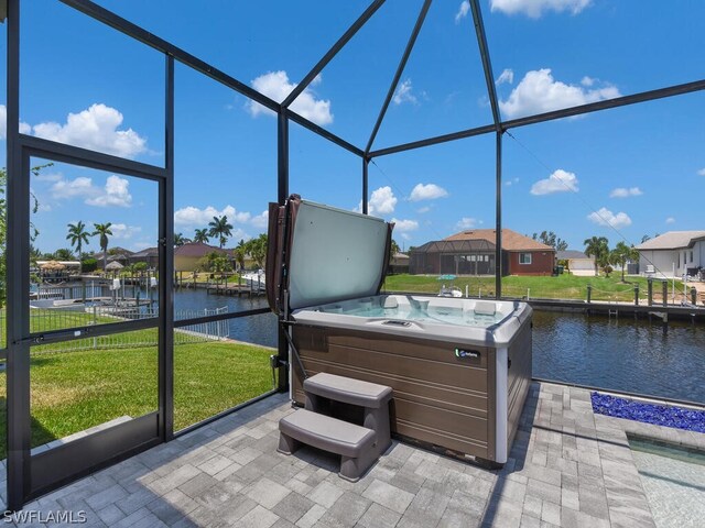 sunroom / solarium featuring a jacuzzi and a water view