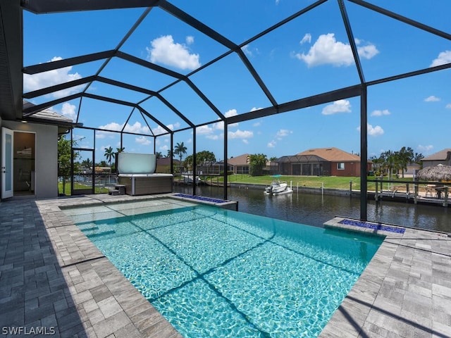 view of pool with glass enclosure, a water view, and a patio