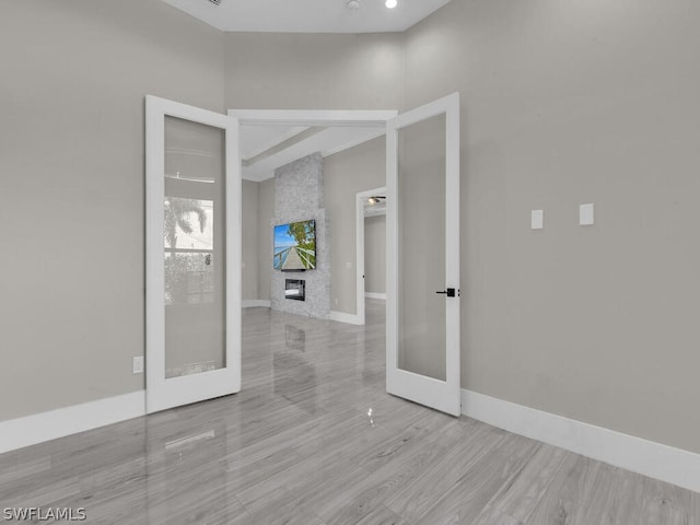 empty room with light hardwood / wood-style flooring and french doors