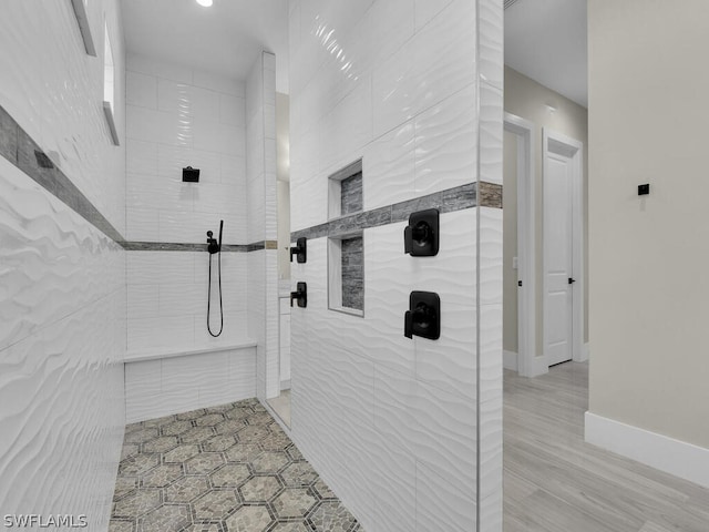 bathroom with hardwood / wood-style floors and tiled shower