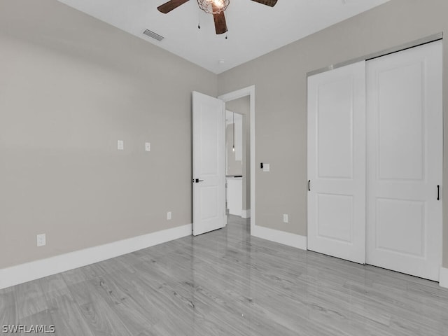 unfurnished bedroom with ceiling fan, light hardwood / wood-style floors, and a closet