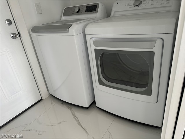 clothes washing area featuring tile flooring and washing machine and clothes dryer