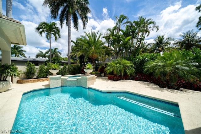 view of swimming pool with an in ground hot tub