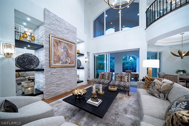 living room with a chandelier, a towering ceiling, and hardwood / wood-style floors