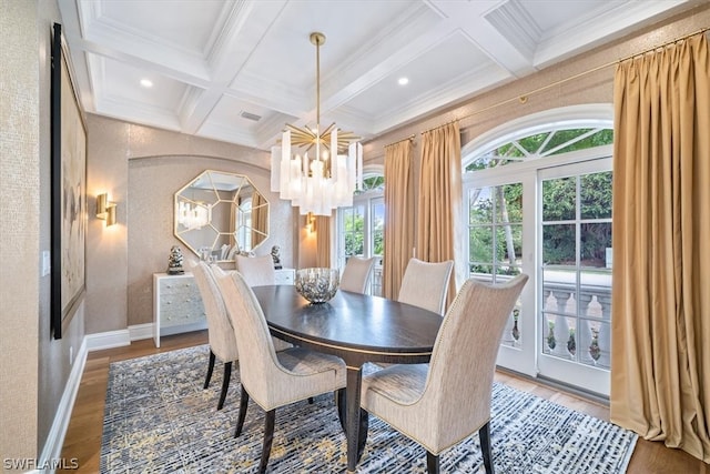 dining space featuring wood-type flooring, beamed ceiling, crown molding, a chandelier, and coffered ceiling