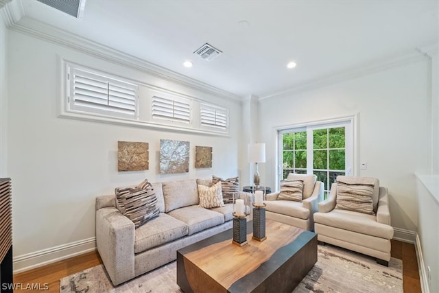 living room with ornamental molding and light hardwood / wood-style floors