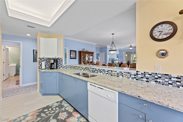 kitchen with light stone counters, backsplash, blue cabinetry, white dishwasher, and sink