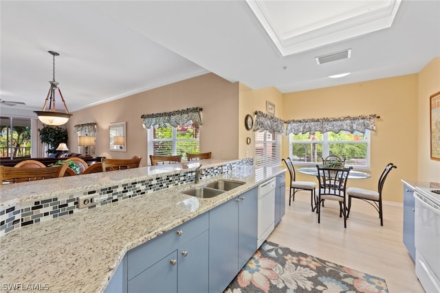 kitchen with plenty of natural light, sink, light wood-type flooring, and backsplash