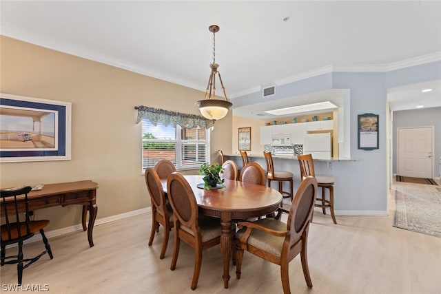 dining space featuring light hardwood / wood-style floors and ornamental molding