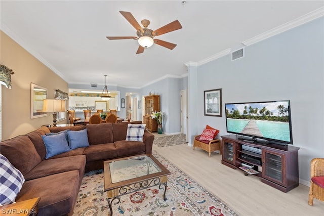 living room with ceiling fan, ornamental molding, and hardwood / wood-style flooring