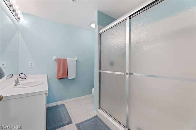 bathroom featuring a shower with door, tile flooring, toilet, and oversized vanity