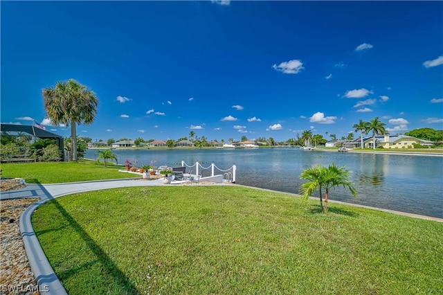 view of dock featuring a lawn and a water view